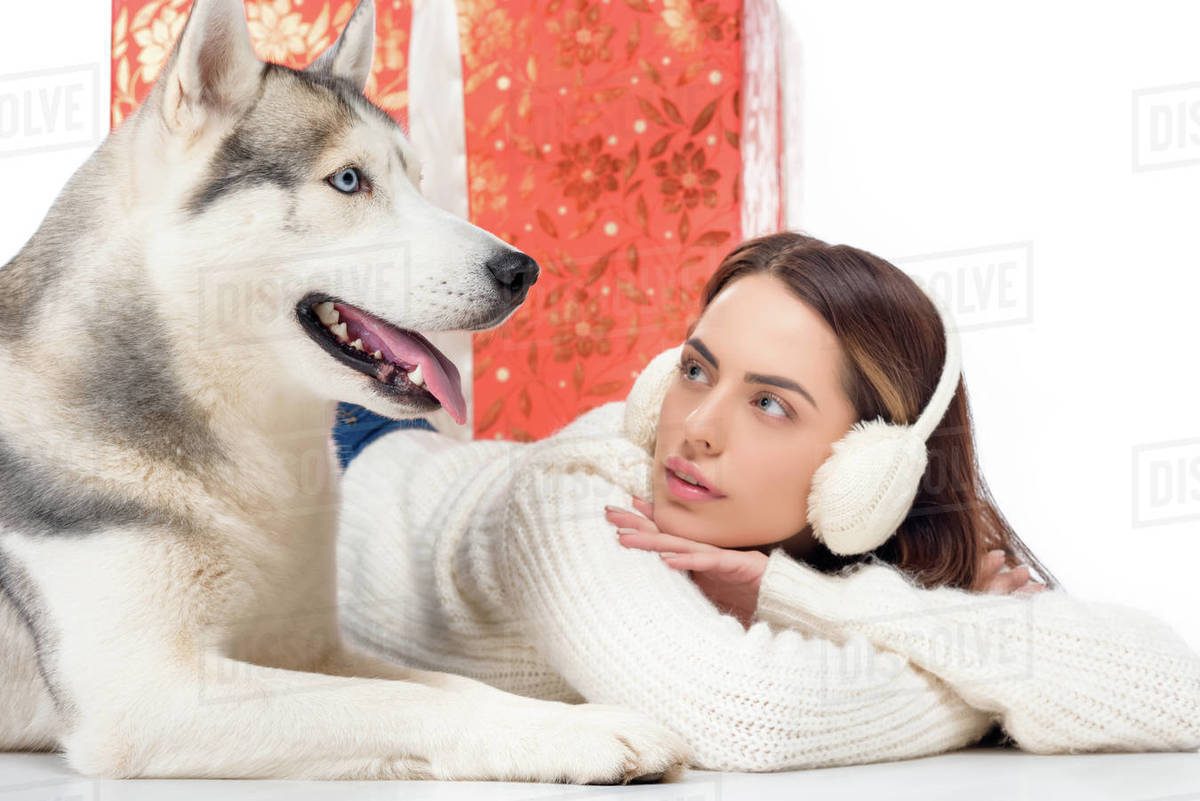 husky dog and beautiful woman in winter earmuffs with big