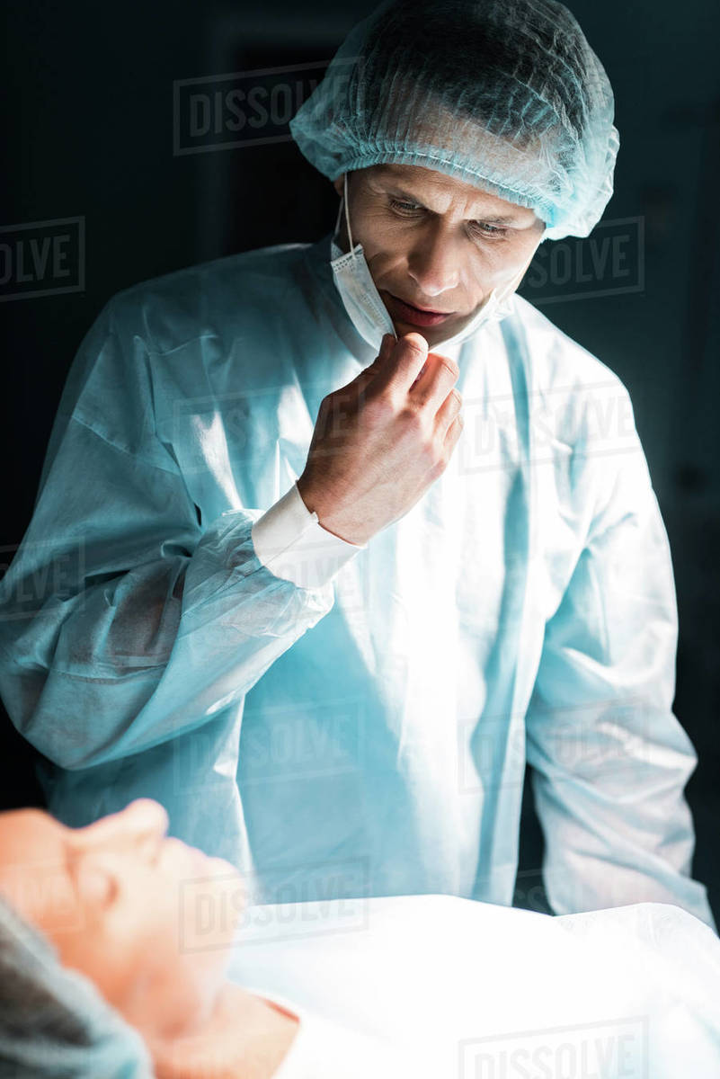 Doctor looking at patient in surgery room - Stock Photo - Dissolve