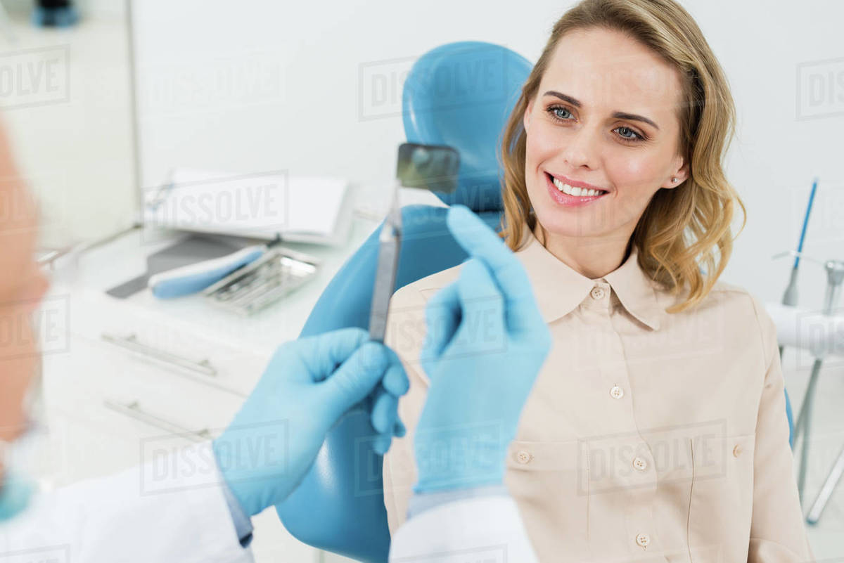 Dentist showing female patient xray in modern dental clinic Stock