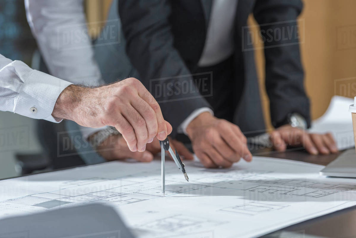 Cropped shot of architects using compass for building plans Stock