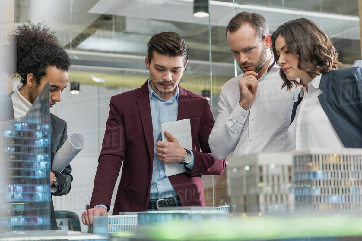 Group of thoughtful architects discussing building models at office Royalty-free stock photo