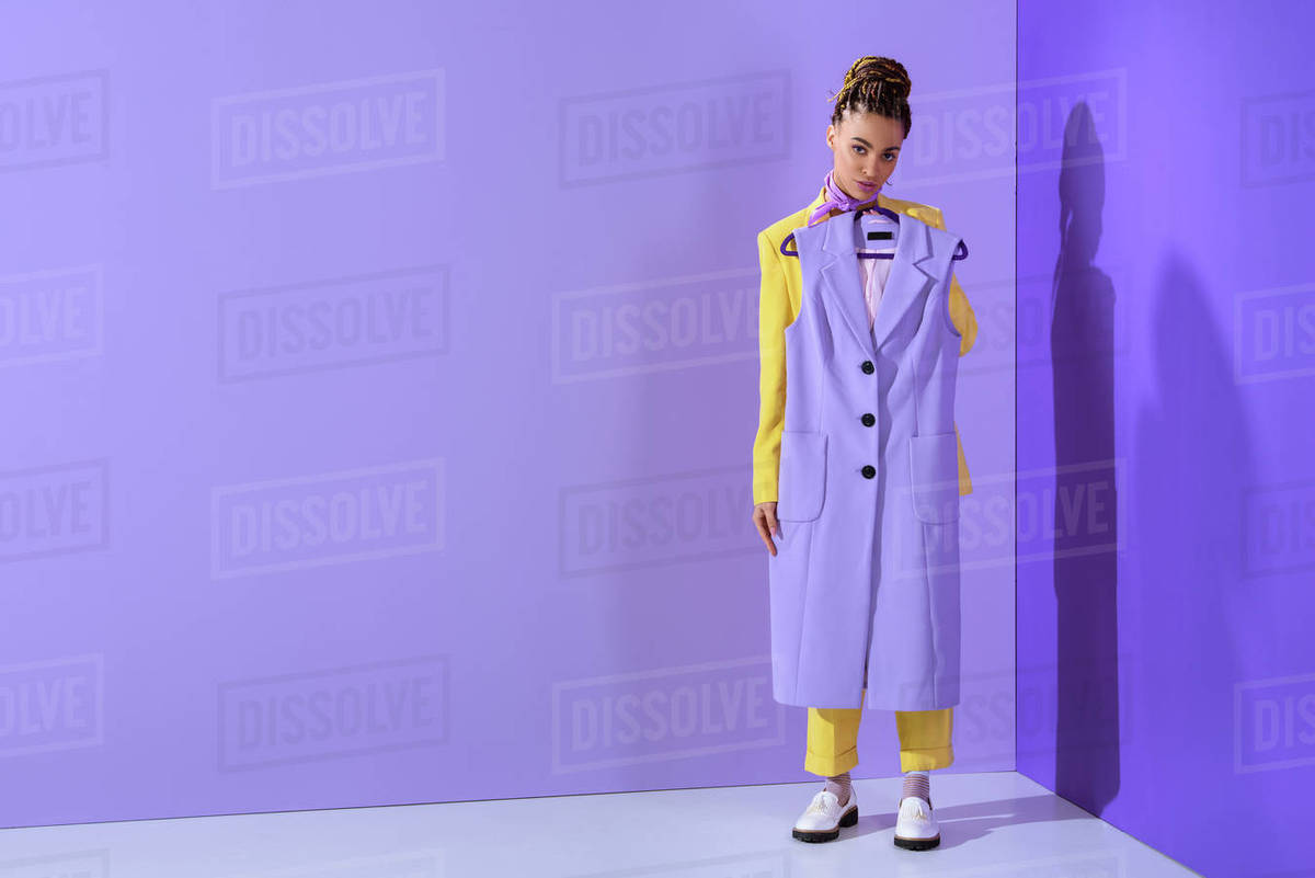 African American girl in yellow suit holding purple waistcoat, on