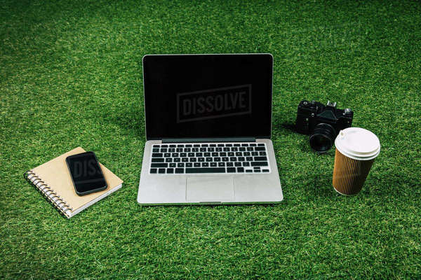 Laptop, smartphone, photo camera and coffee to go in disposable cup on ...