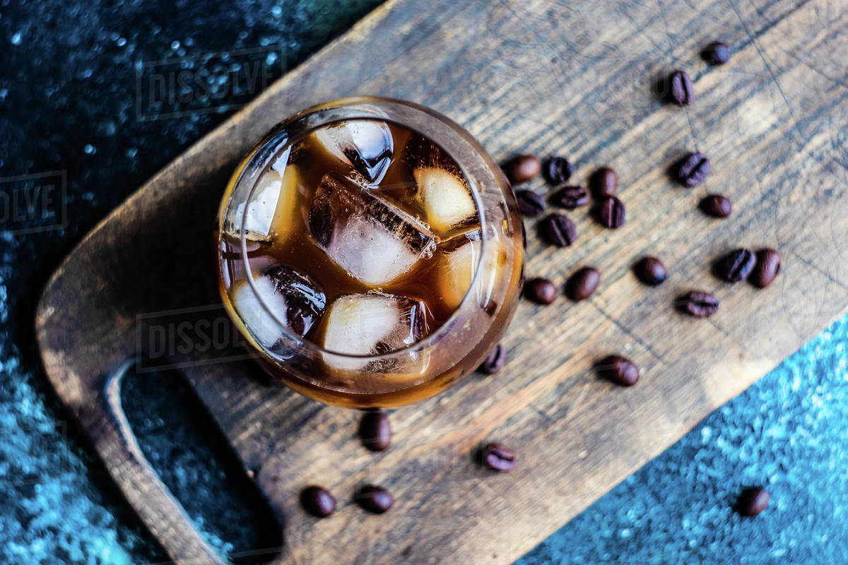 Close-up of an iced coffee drink on a chopping board with roasted coffee beans Royalty-free stock photo