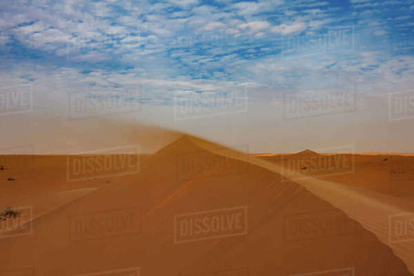 Sand blowing off the ridge of a sand dune in the desert, Saudi Arabia ...