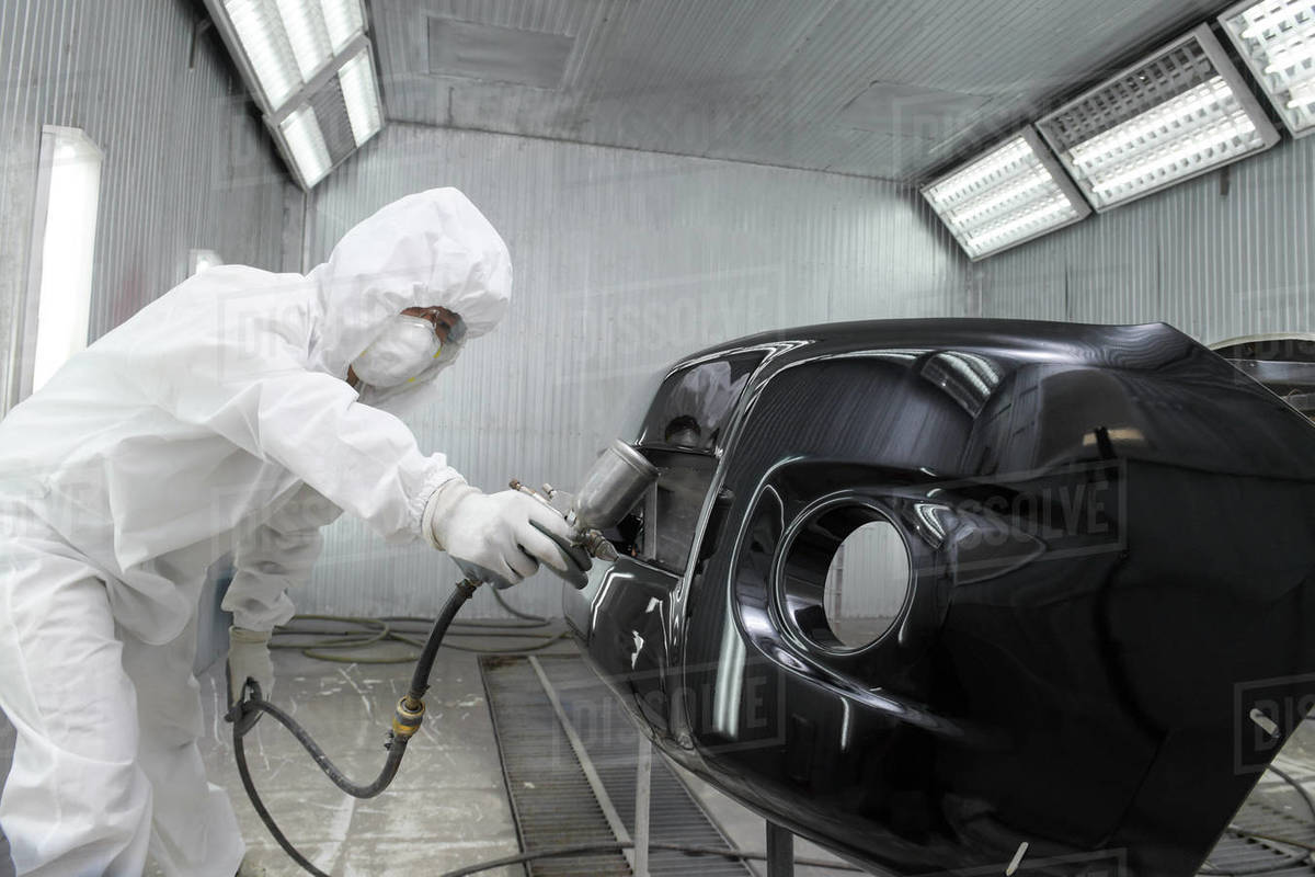 Mechanic respraying a car in a garage Stock Photo Dissolve