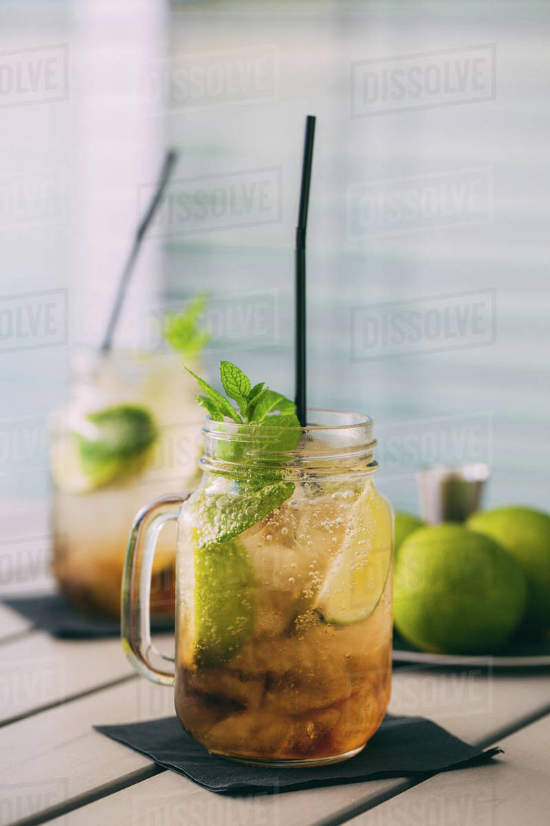 two Mojitos cocktail prepared with lime, mint, rum, soda and ice in