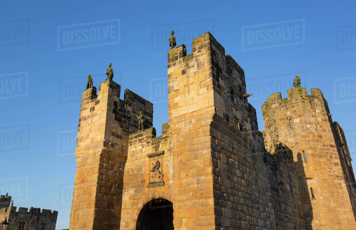 The medieval barbican and gatehouse of Alnwick Castle, sunset, Alnwick, Northumberland, England, United Kingdom, Europe Rights-managed stock photo