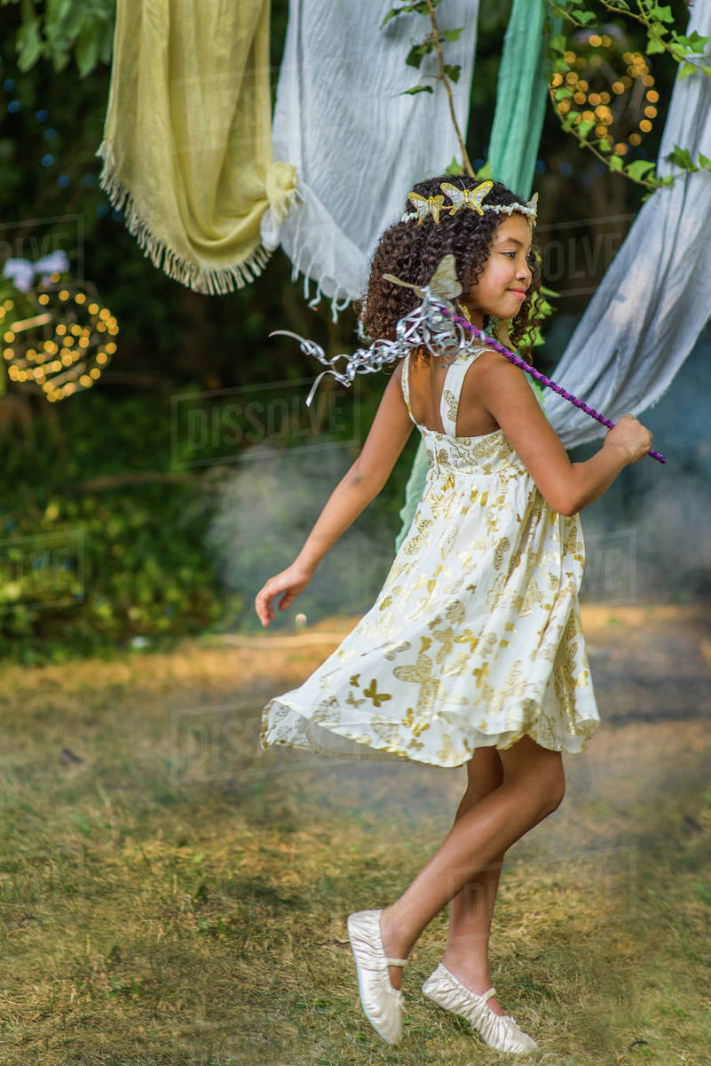 Young girl dressed as fairy, holding wand, playing outdoors Royalty-free stock photo