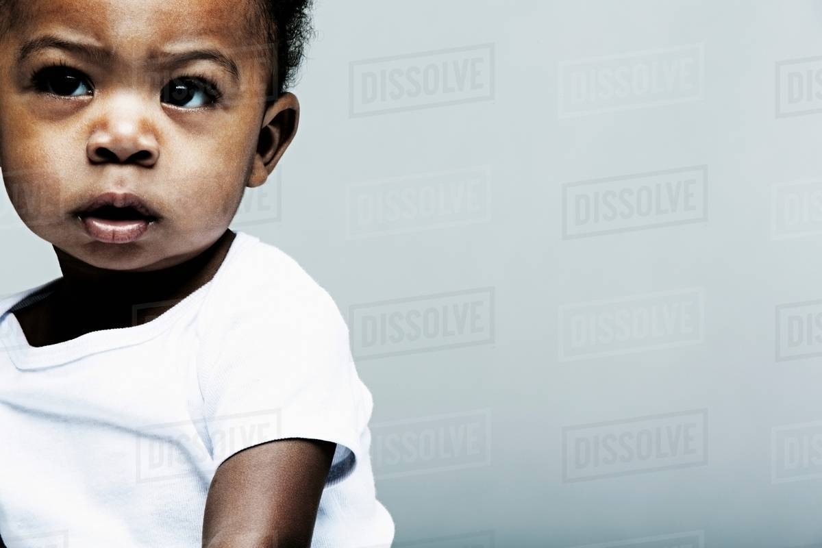 Portrait of baby boy wearing white vest Stock Photo Dissolve