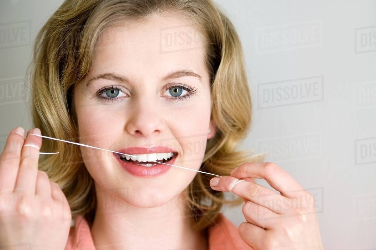 Woman with dental floss Stock Photo Dissolve