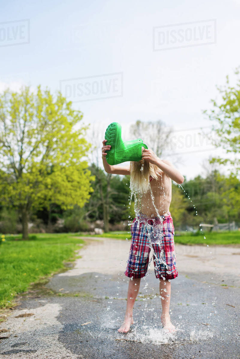 Canada, Kingston, Shirtless boy (89) pouring water from rubber boot on