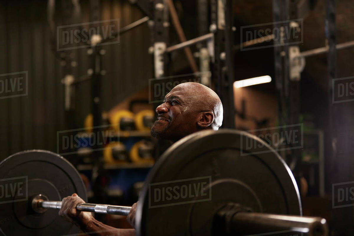 Man with sweat on face weightlifting in gym Stock Photo Dissolve