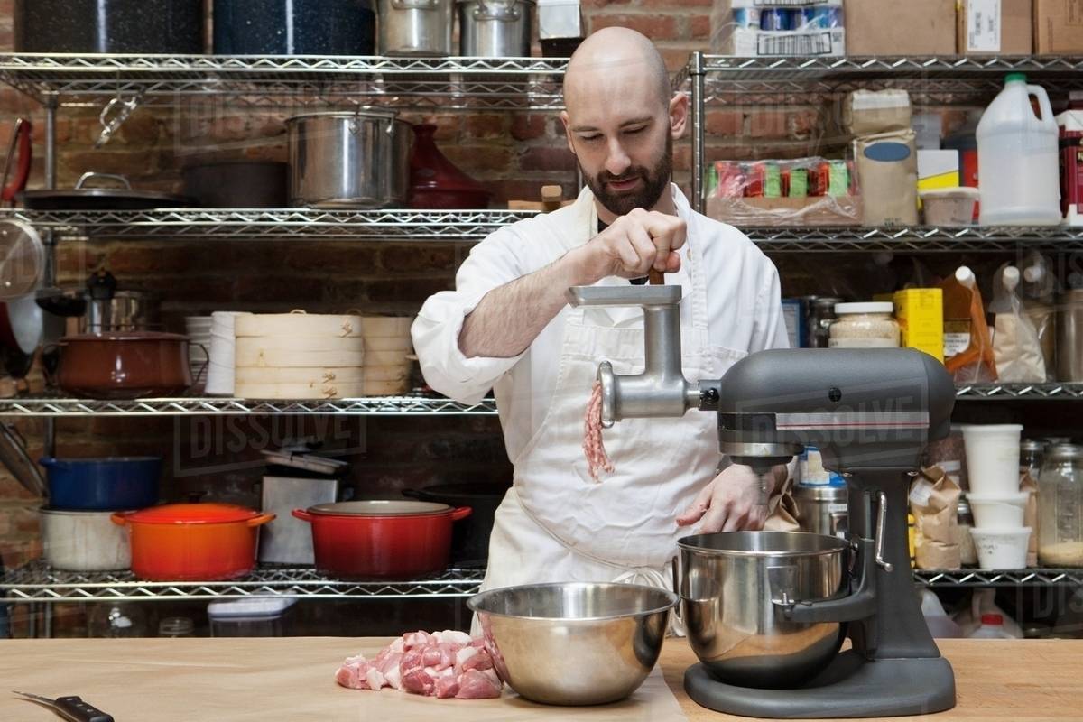 Butcher making ground meat Stock Photo Dissolve