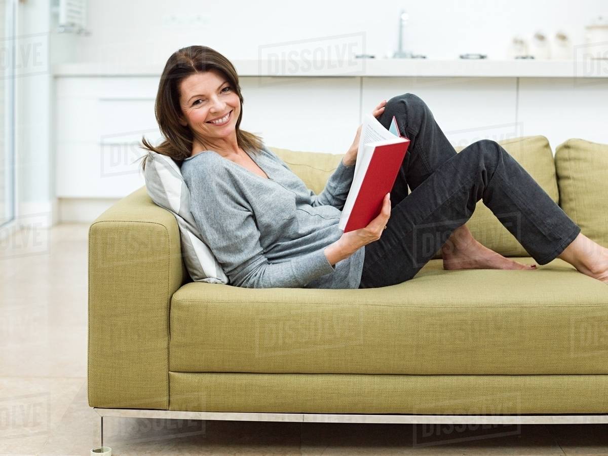 Woman Sitting On Sofa Reading Book Stock Photo Dissolve Woman Sitting On Sofa Reading Book