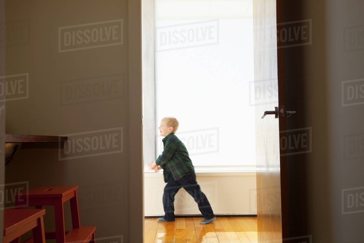 Boy playing in hallway Stock Photo Dissolve