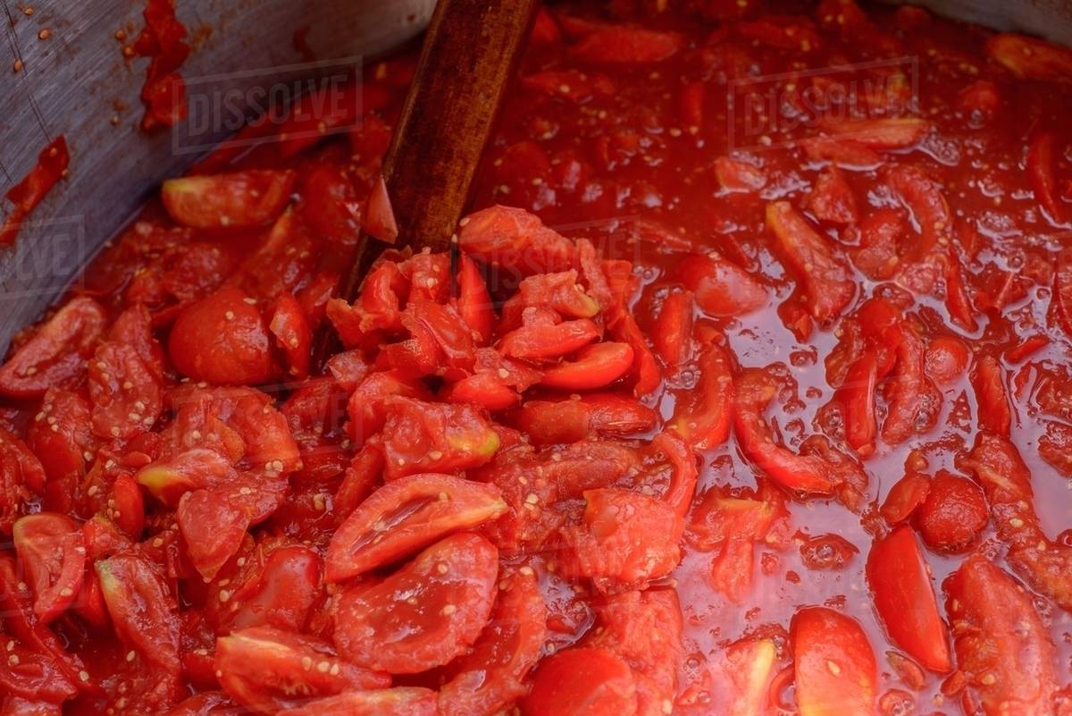 Chopped tomatoes cooking in pan Stock Photo Dissolve