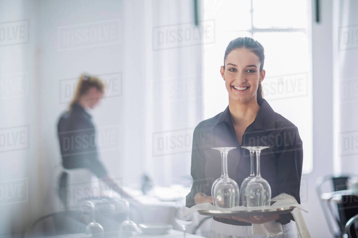Waitresses setting table in restaurant Stock Photo Dissolve
