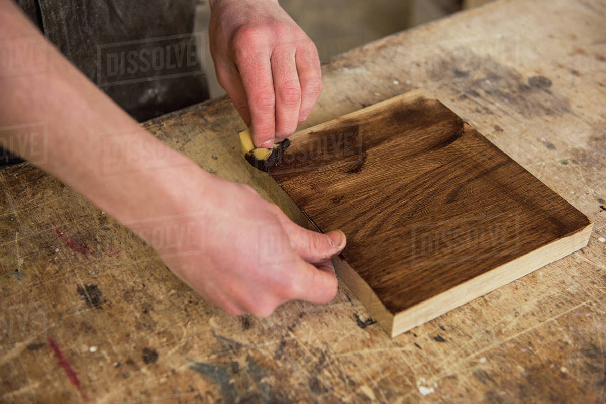 Carpenter painting wooden board in a wooden Profession