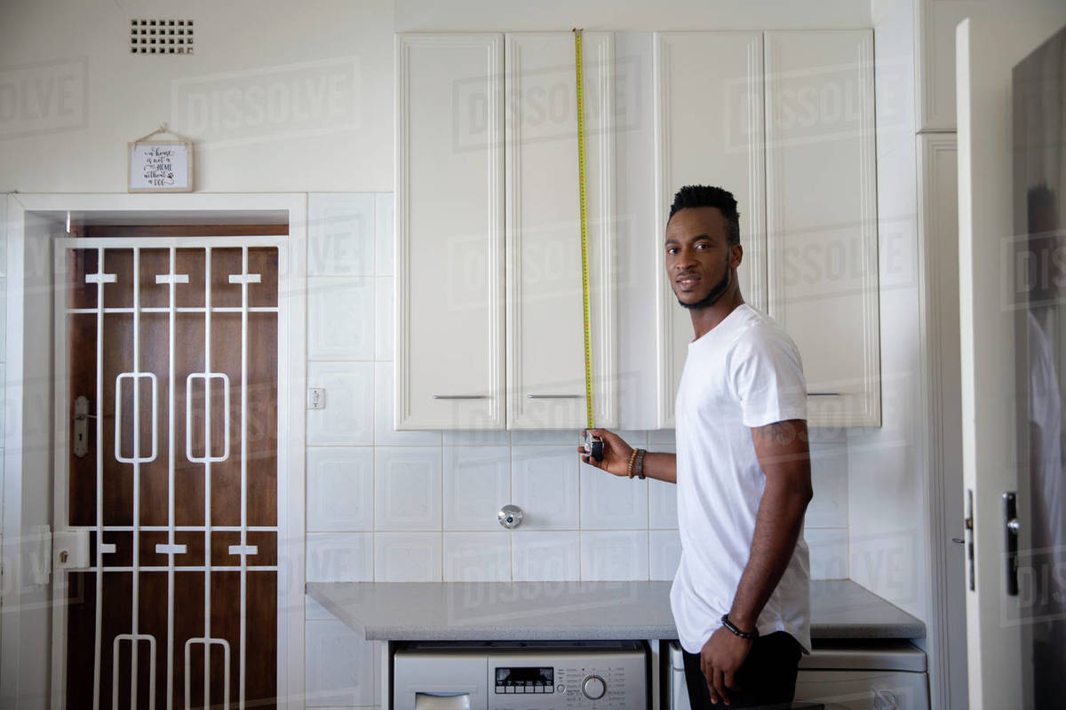 Man measuring kitchen cabinet Royalty-free stock photo