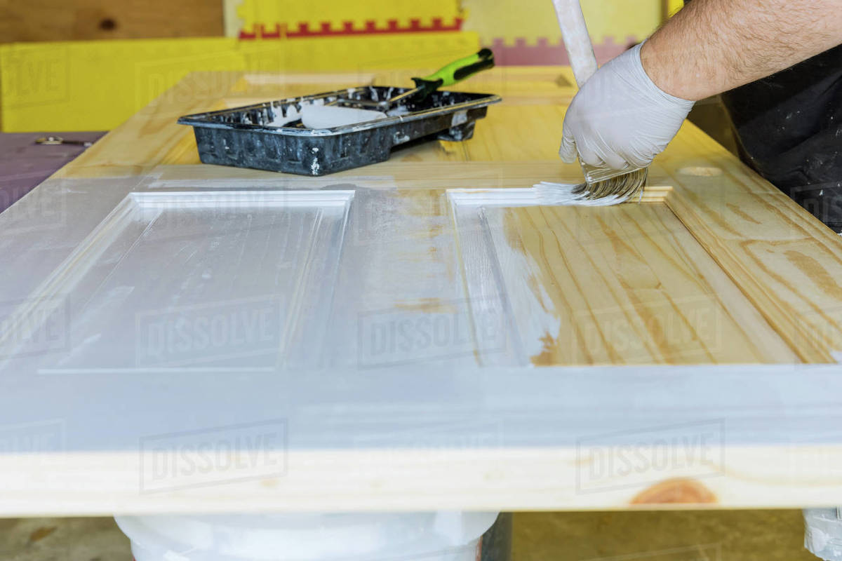 Handyman home renovation painter of painting doors trim using hand paint brush painting with