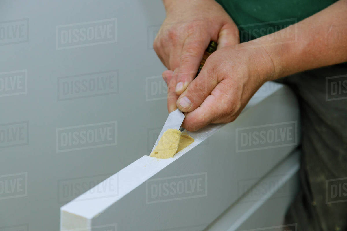 Carpenter working using a chisel a hinge wooden door a hinge is