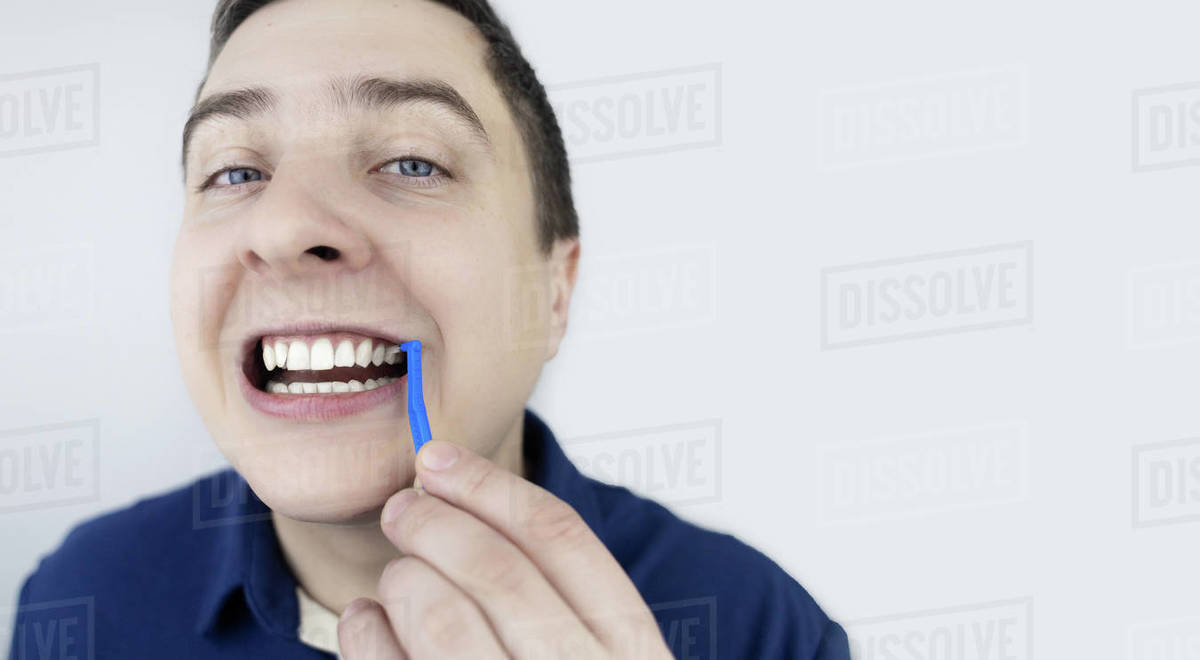 Interdental brush. A man shows a brush for cleaning the interdental