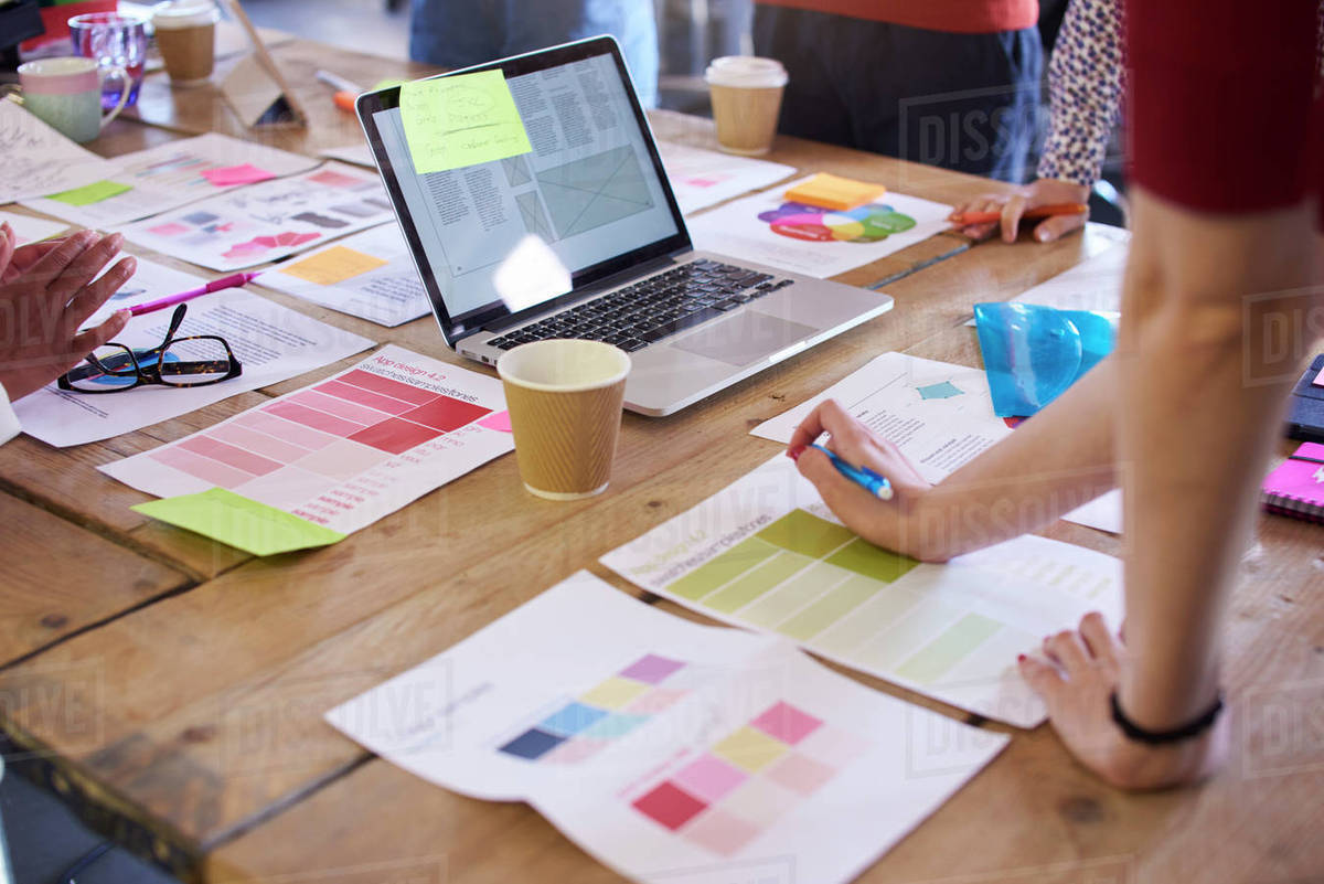 Close up of designers discussing layouts and color schemes Stock