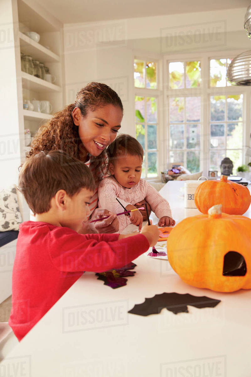 Mother and children making halloween decorations at home Stock Photo