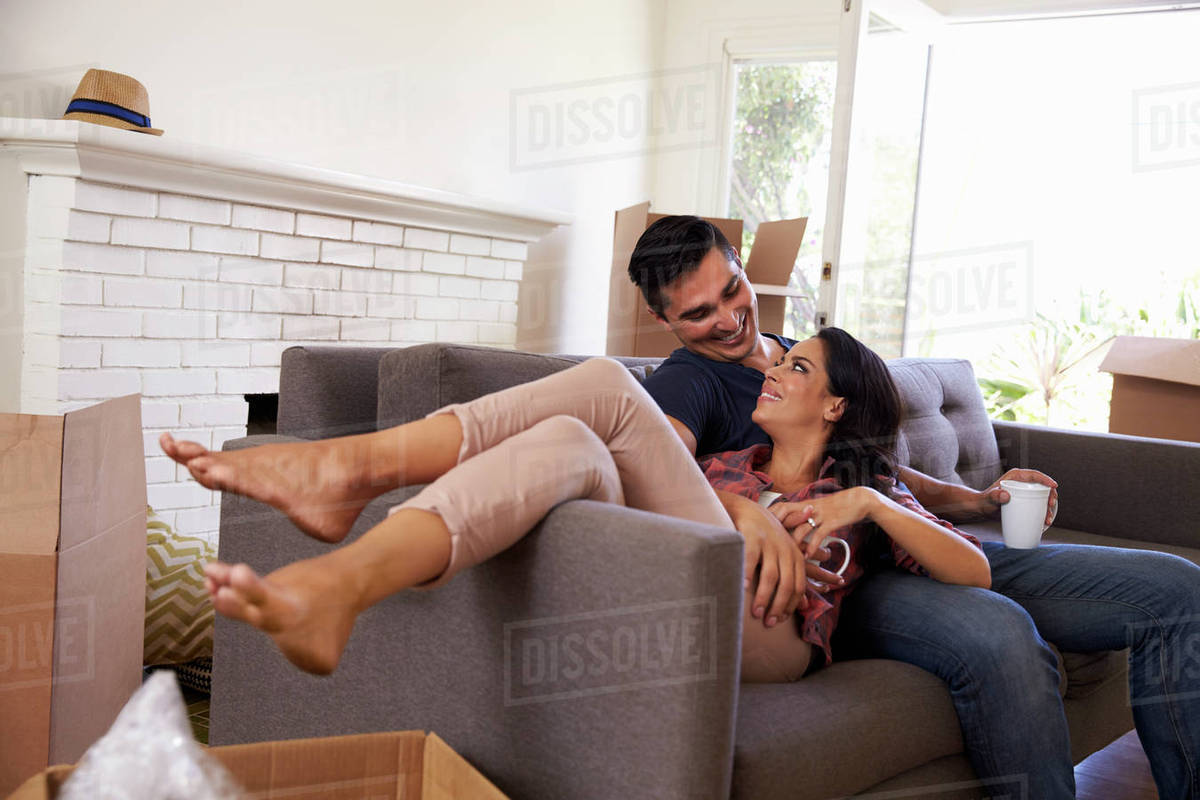 Couple on sofa taking a break from unpacking on moving day Royalty-free stock photo