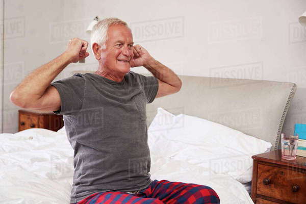 Senior Man Waking Up And Stretching In Bedroom - Royalty-free Stock ...