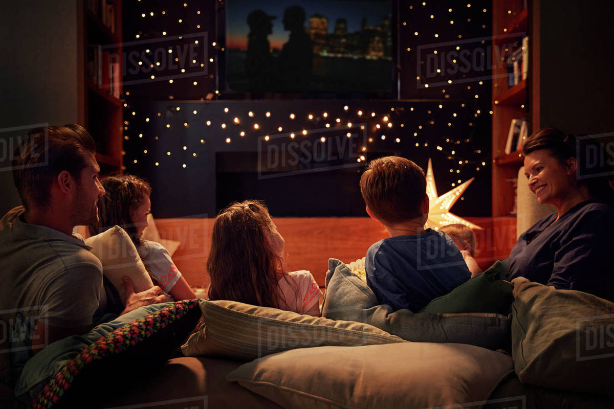 Family Enjoying Movie Night At Home Together Stock Photo Dissolve