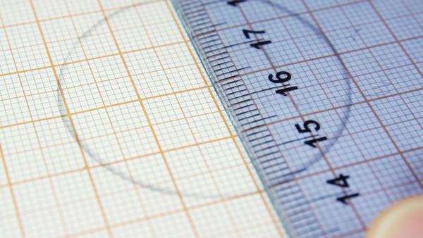 person drawing a circle using compass on the graph paper geometry graph paper