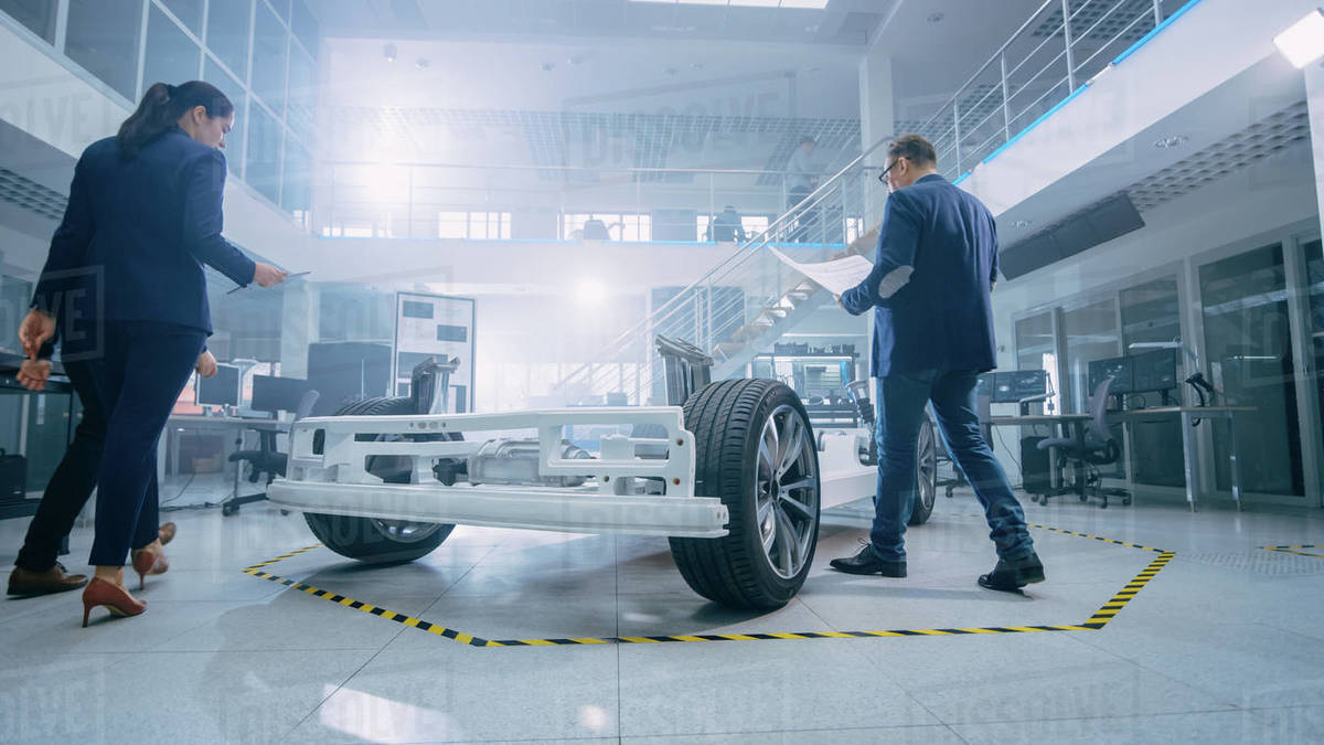 Automotive Design Engineers Talking while Working on Electric Car