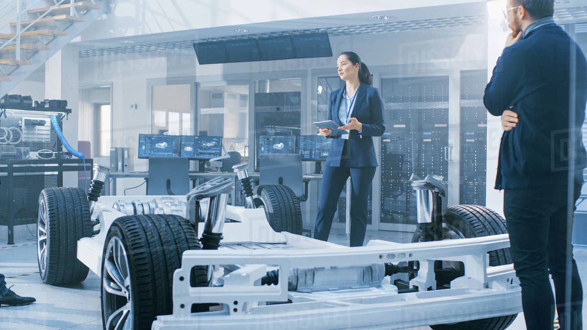 Automotive Design Engineers Talking while Working on Electric Car