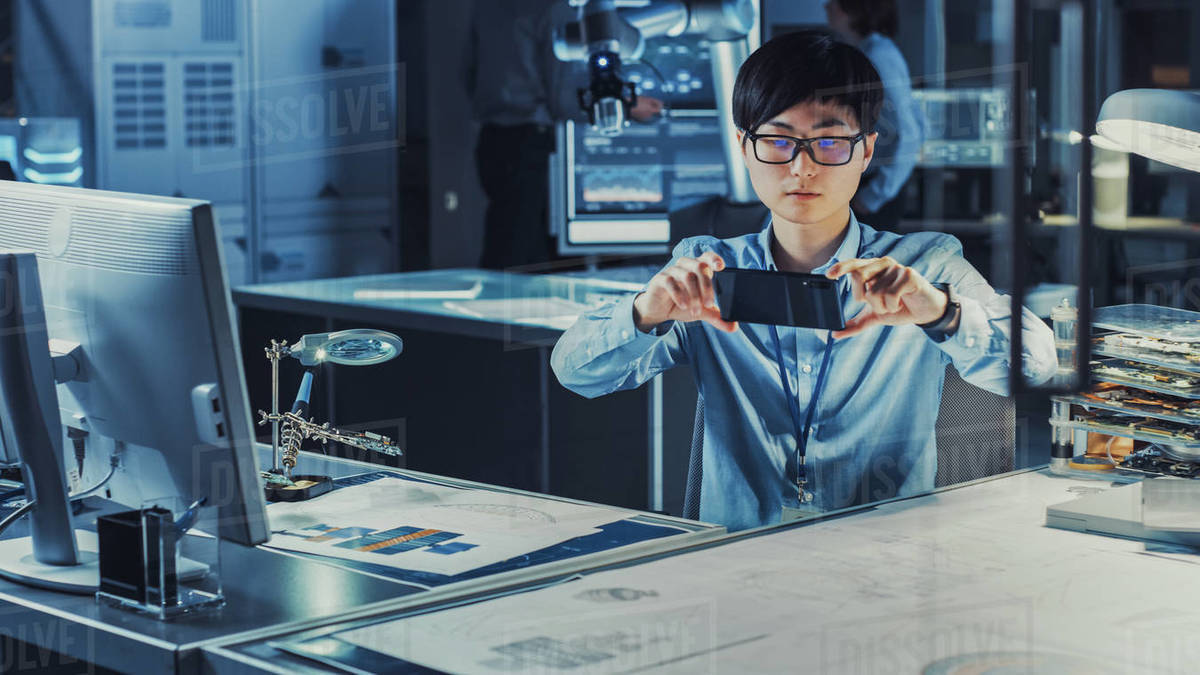 Handsome Japanese Development Engineer in Blue Shirt is Looking at Augmented Realirty From