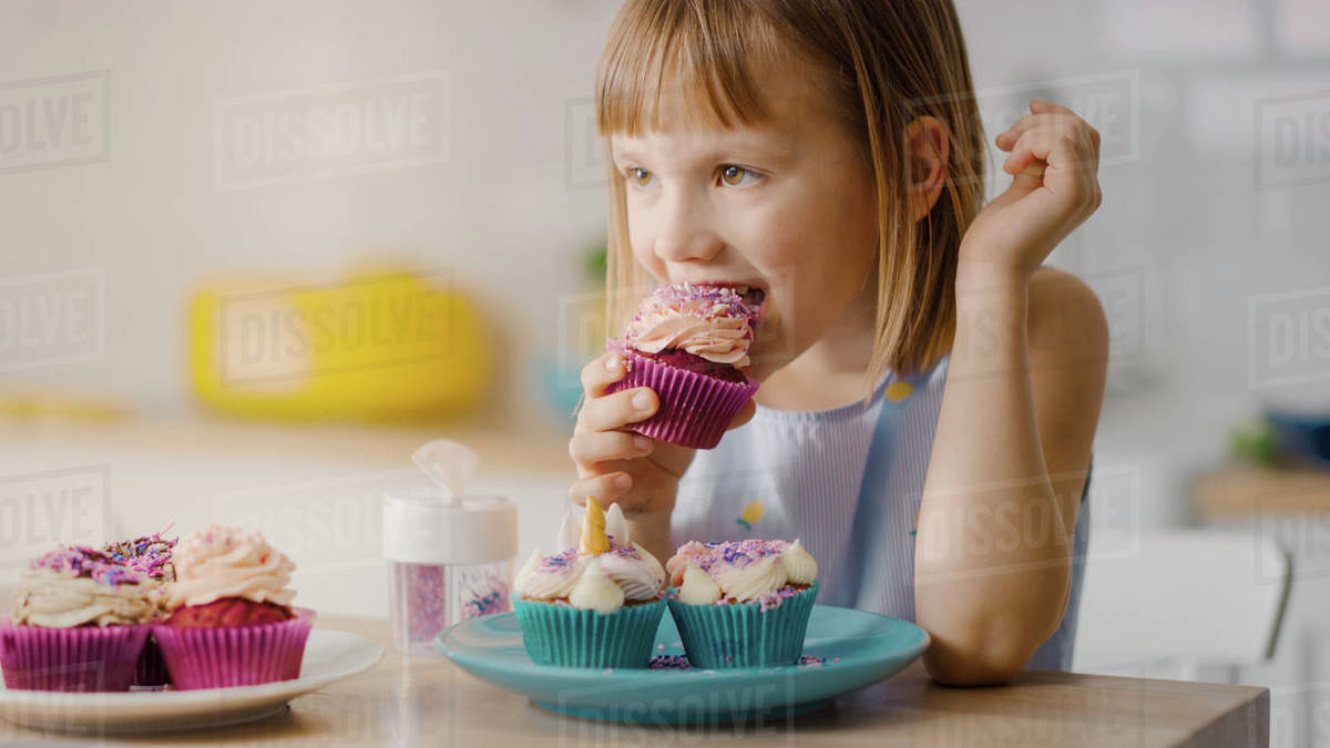In the Kitchen Adorable Little Girl Eats Creamy Cupcake with Frosting