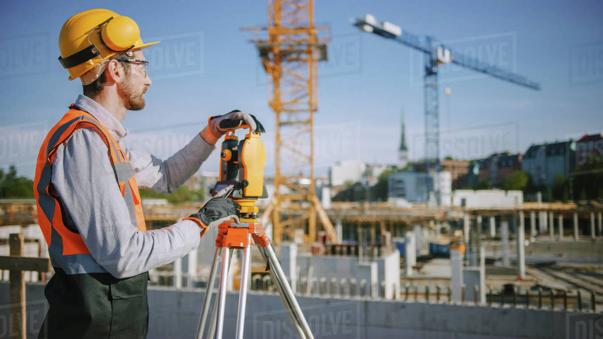 Construction Worker Using Theodolite Surveying Optical Instrument for Measuring Angles in