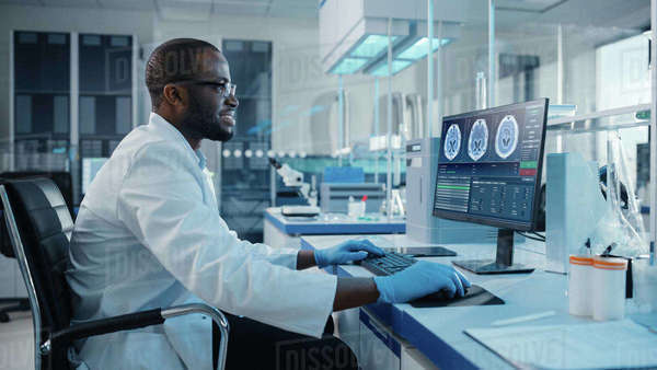 Modern Medical Laboratory: Male Scientist, Typing on Keyboard, Working ...