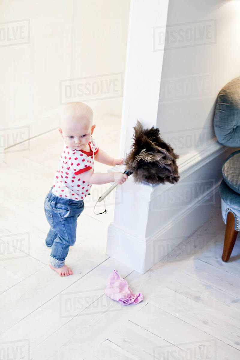 Baby with feather duster Stock Photo Dissolve