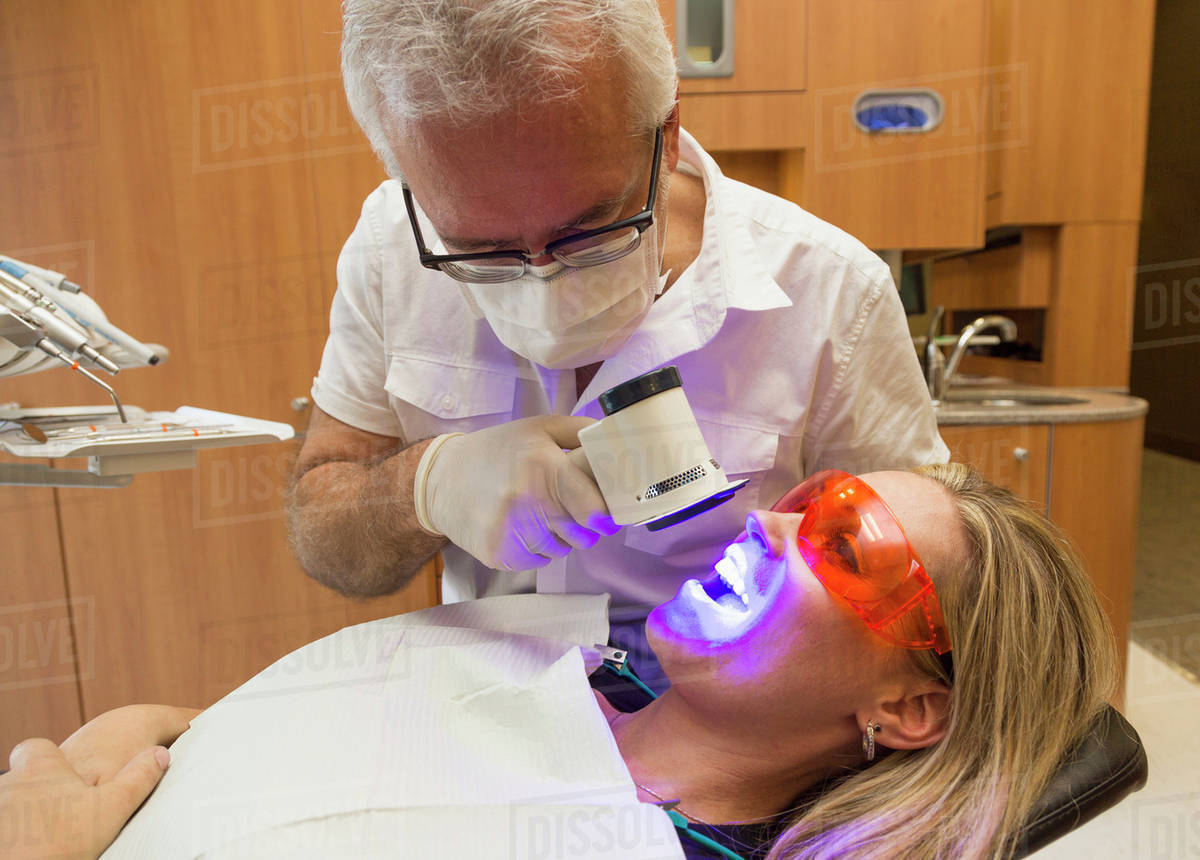 Dentist using fluorescence visualization to check for oral disease