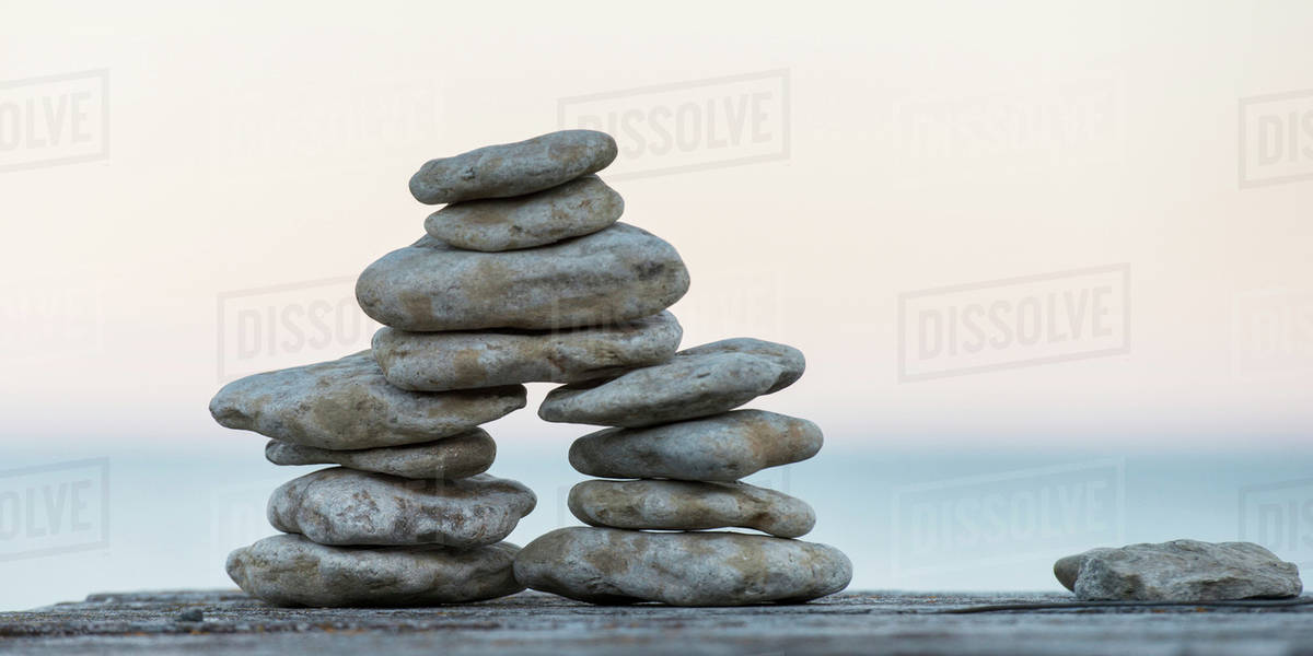 Pile of stones built on a wooden surface with Lake Winnipeg in the