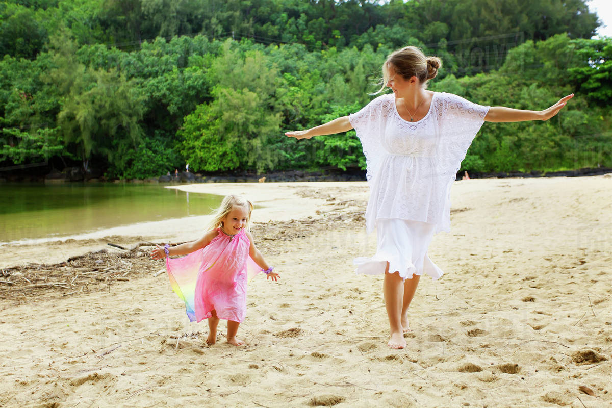 A mother plays on the beach with her young daughter; Kauai, Hawaii