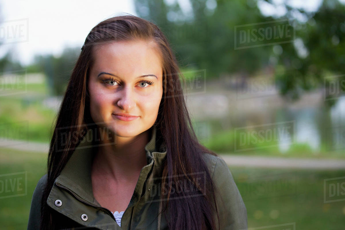 Portrait of a beautiful young woman in a park at twilight; St. Albert, Alberta, Canada Stock
