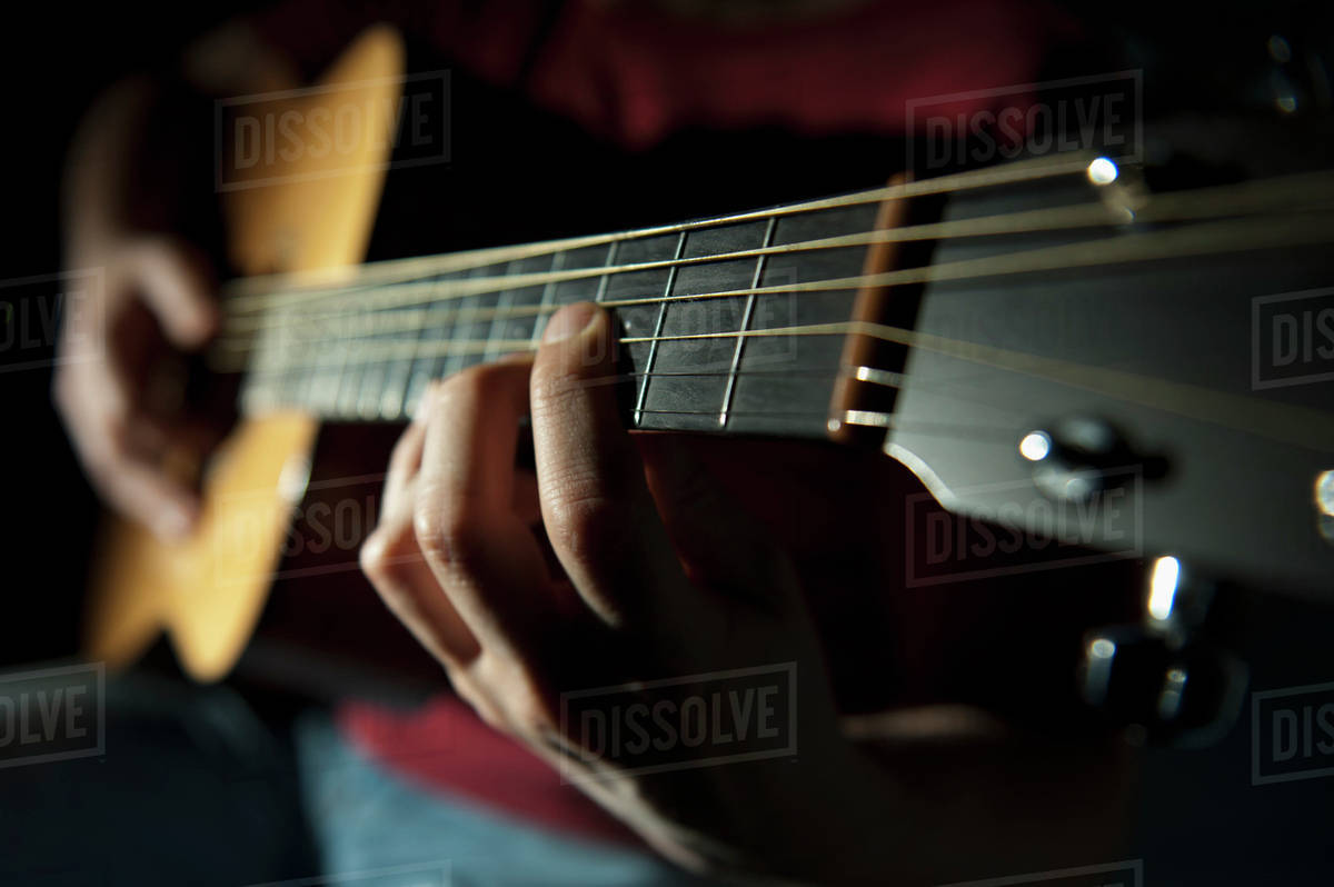Playing A Guitar; Edmonton, Alberta, Canada Stock Photo Dissolve