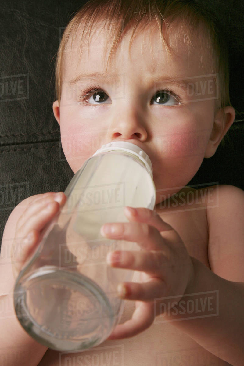 A Baby Laying On It's Back Drinking Milk From A Bottle; Edmonton