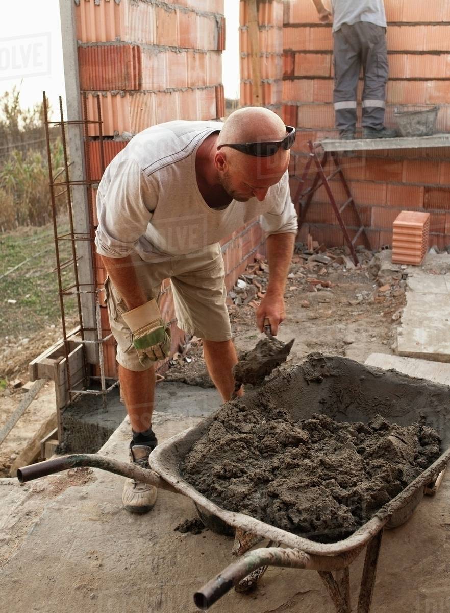 A Man Mixing Cement In A Wheelbarrow Stock Photo Dissolve