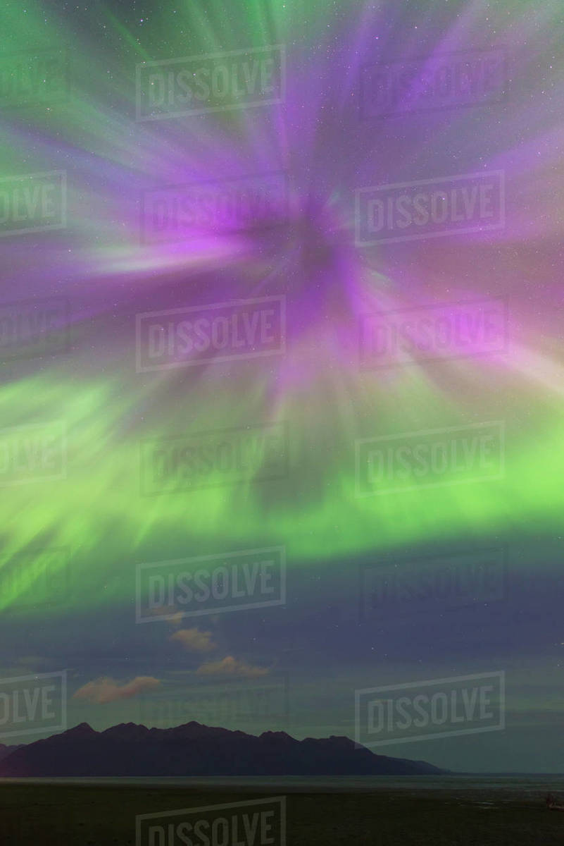 The Aurora Borealis Bursts Over The Kenai Mountains And The Mudflats Of