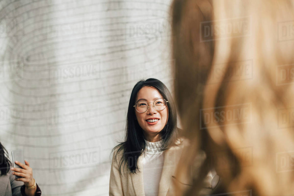 Smiling businesswoman listening to female coworker in meeting Royalty-free stock photo