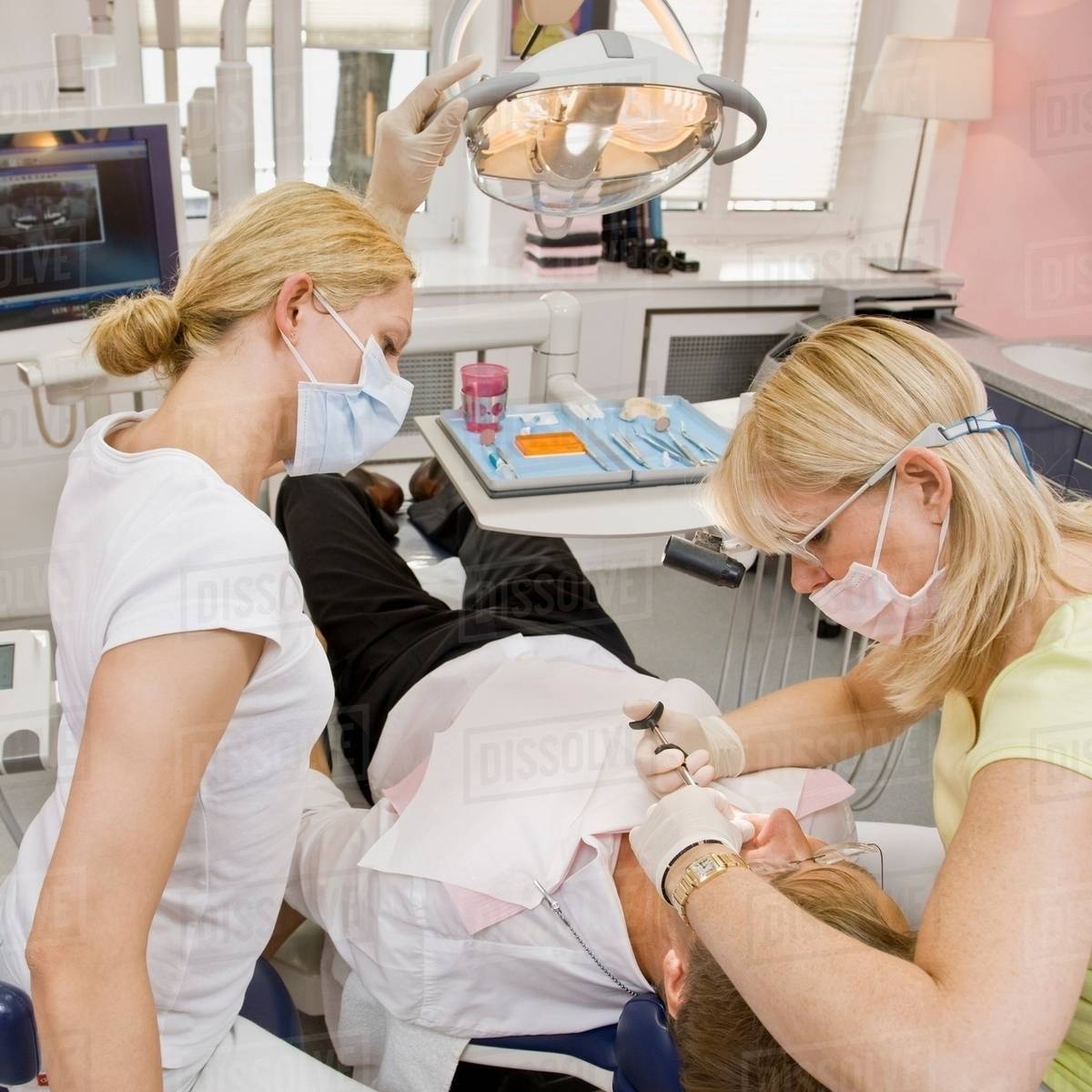 Female dentist working on a male patient Stock Photo Dissolve